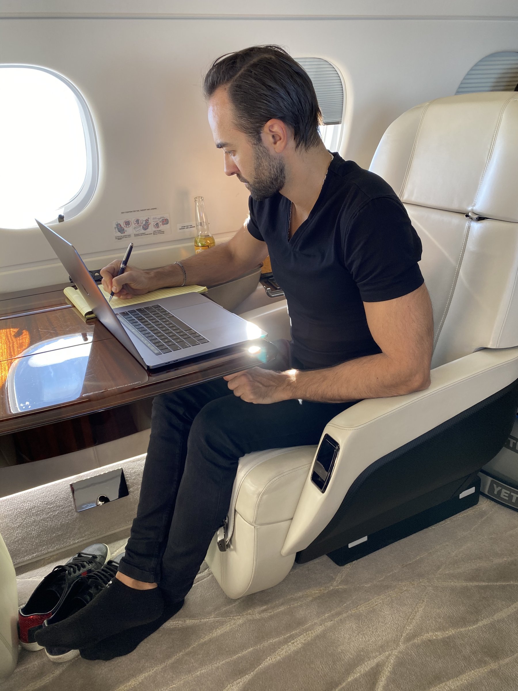 Andrea d'Agostini writing at his laptop in flight