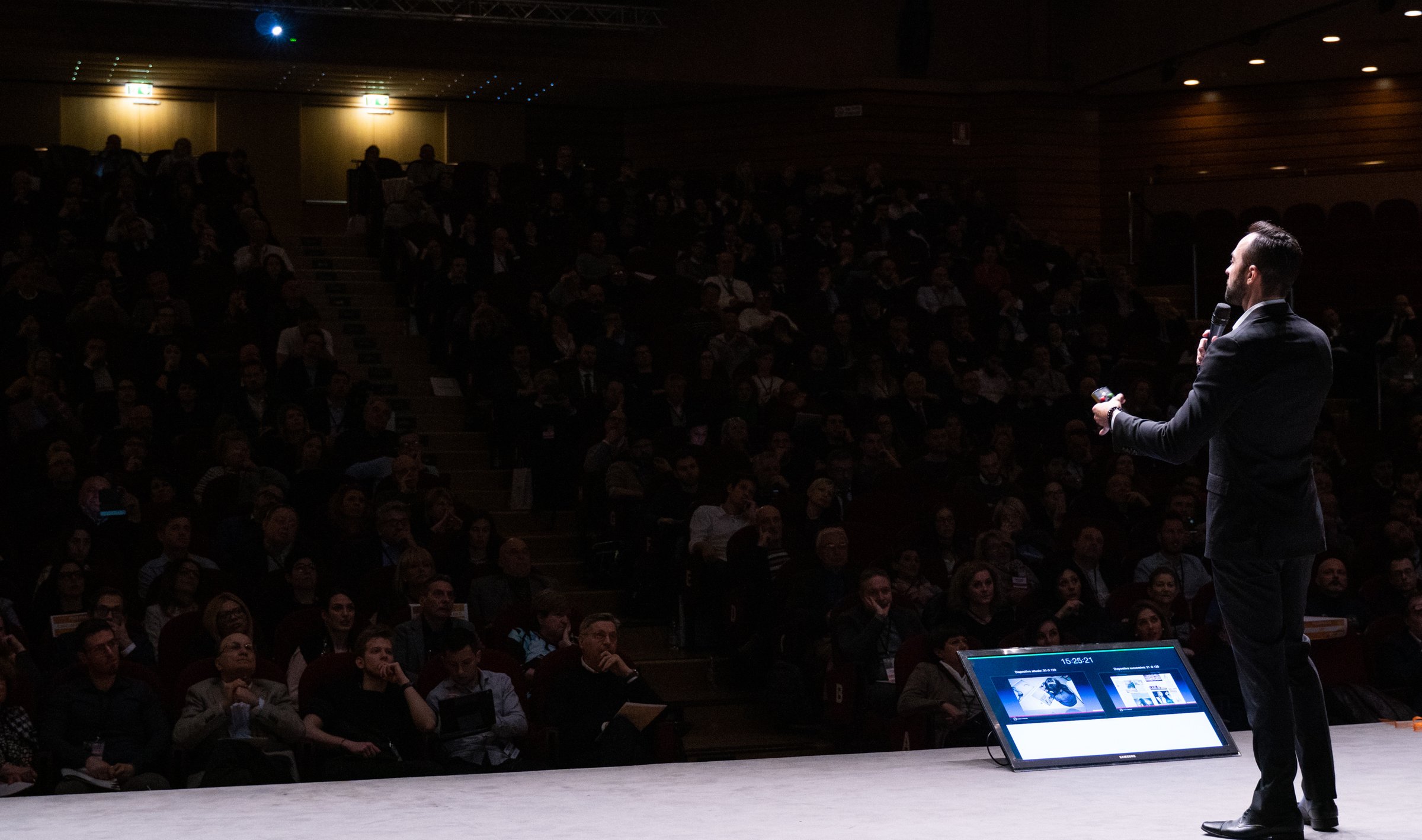 Andrea d'Agostini on stage in front of a packed auditorium