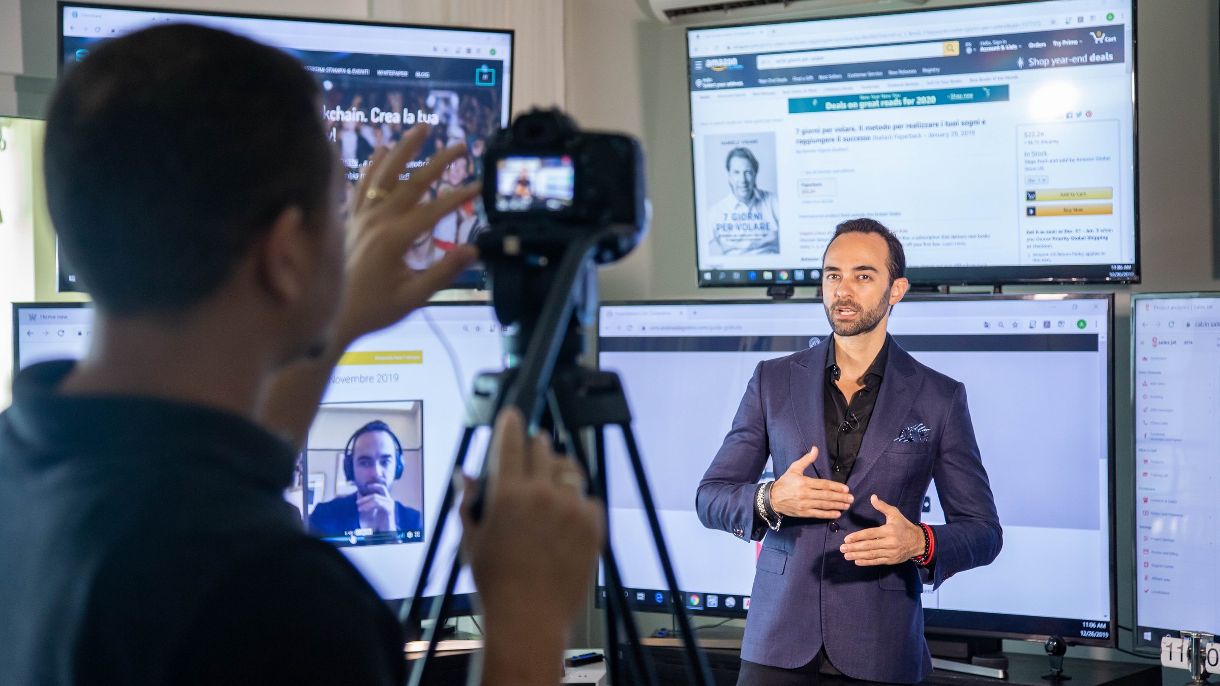 Andrea d'Agostini filming in the studio, surrounded by live screens